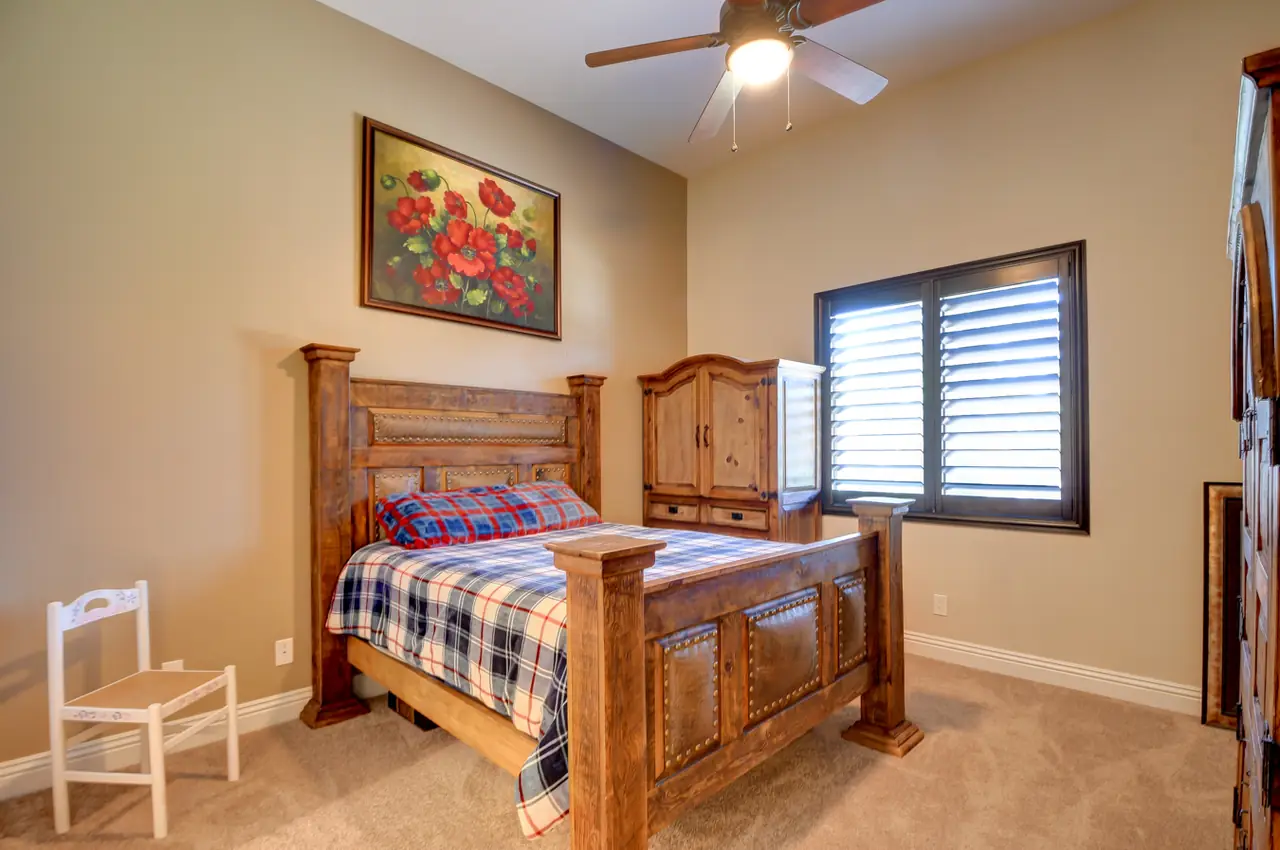 Bedroom with a ceiling fan and shuttered window