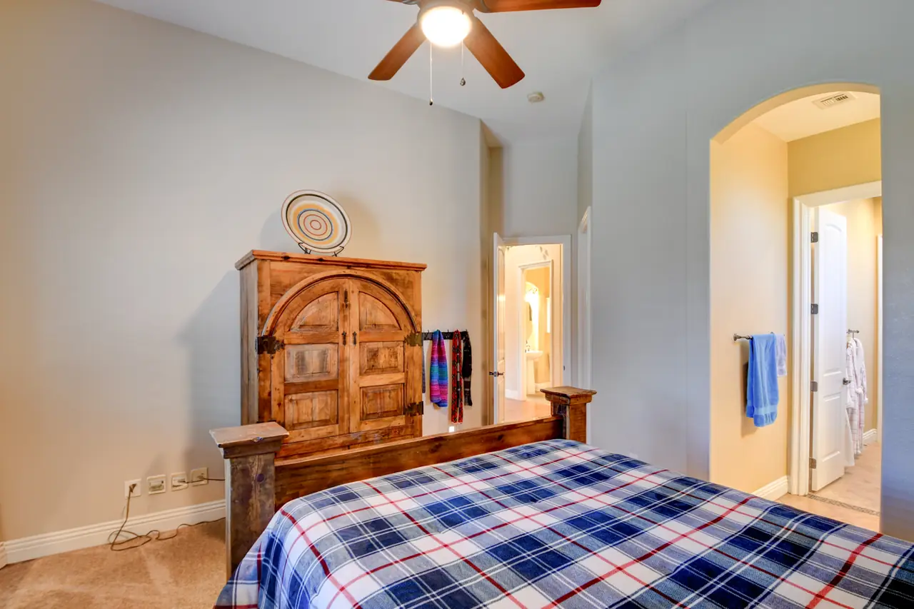 Bedroom with an arched doorway and a ceiling fan