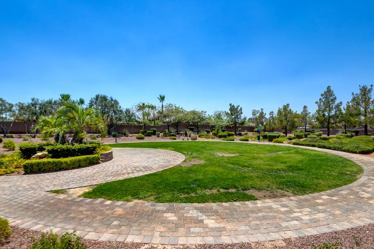 Community park with a circular lawn and paver walk in Legends at Log Cabin