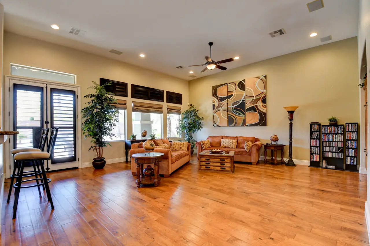 Family room with hardwood floors, shuttered windows and French doors to the backyard