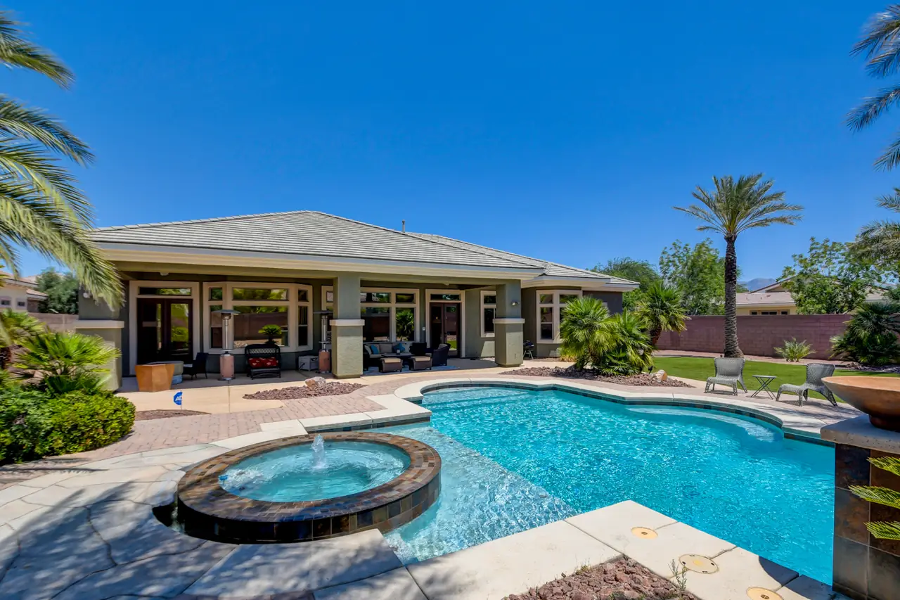 Pool, spa and waterfall feature in front of the rear of the home