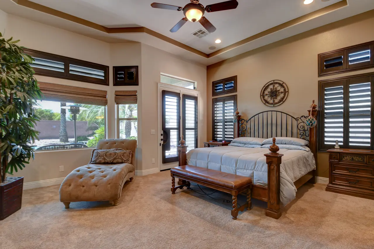Primary bedroom with a coffered ceiling and a sitting area by the windows