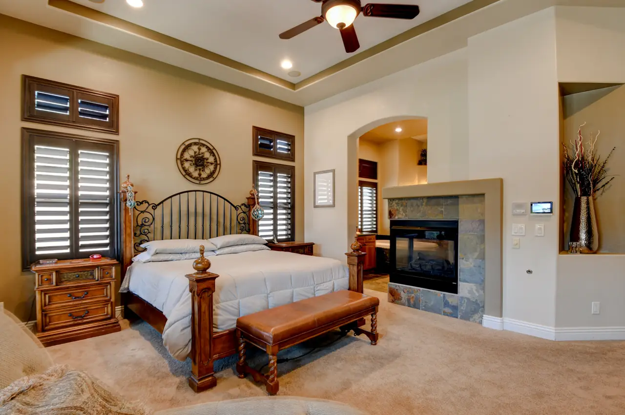 Primary bedroom with a two-sided fireplace and an arched opening to the bath